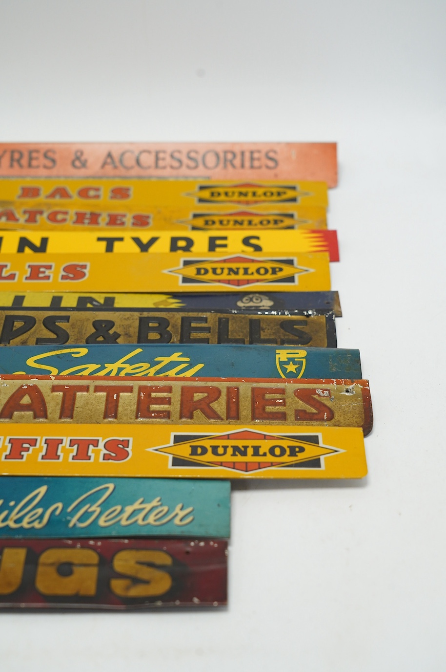 Motoring interest: twelve mid century tinplate advertising shelf strips, largest 48cm, together with a Michelin printed card advertising sign. Condition - poor, fair and good